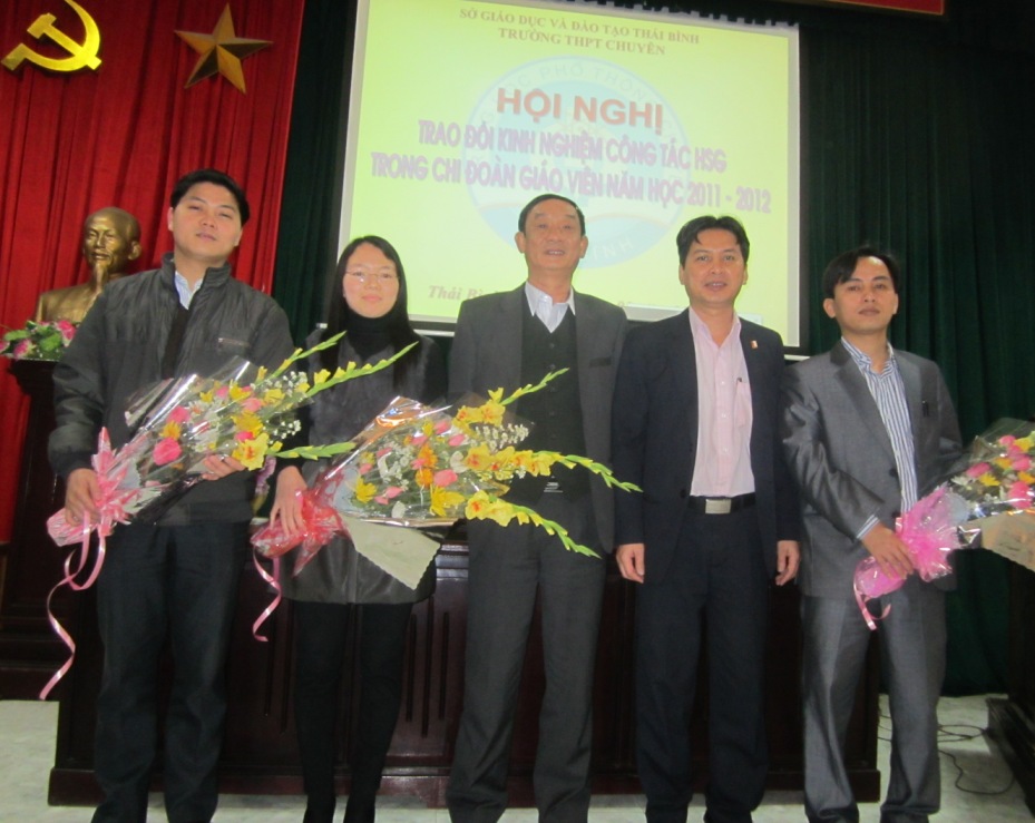 Thầy Nguyễn Quang Thuấn và thầy Bùi Tuấn Anh tặng hoa chúc mừng các đồng chí đoàn viên có thành tích cao trong công tác HSG.